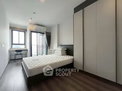 Modern bedroom with large window and sleek furniture