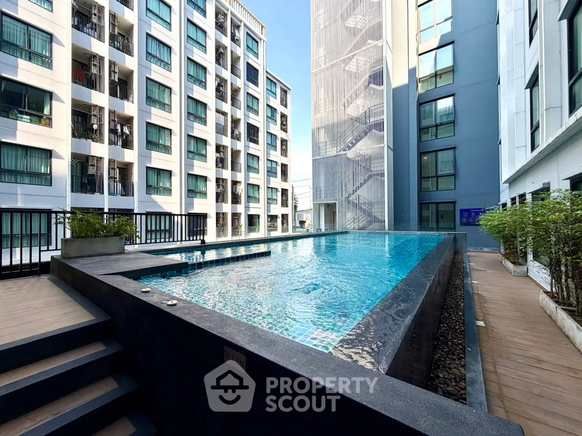 Modern apartment complex with a sleek outdoor pool and contemporary architecture.