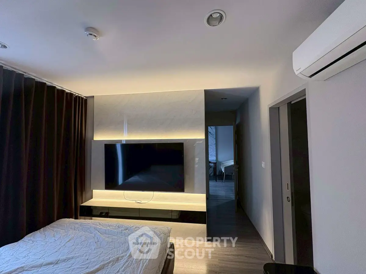 Modern bedroom with sleek TV setup and air conditioning, perfect for comfort and relaxation.