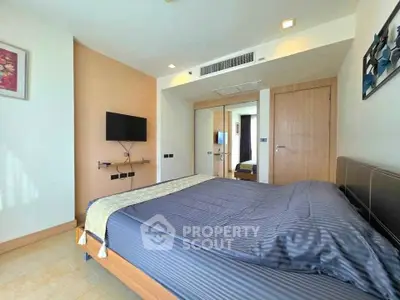 Modern bedroom with stylish decor and wall-mounted TV in a cozy apartment.