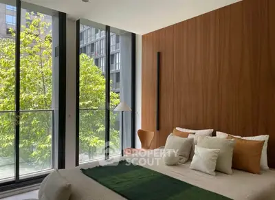 Modern bedroom with floor-to-ceiling windows and lush greenery view.