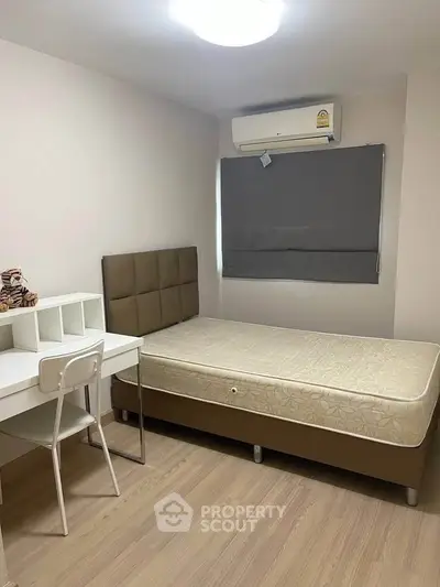 Cozy bedroom with modern furnishings and air conditioning, perfect for comfortable living.