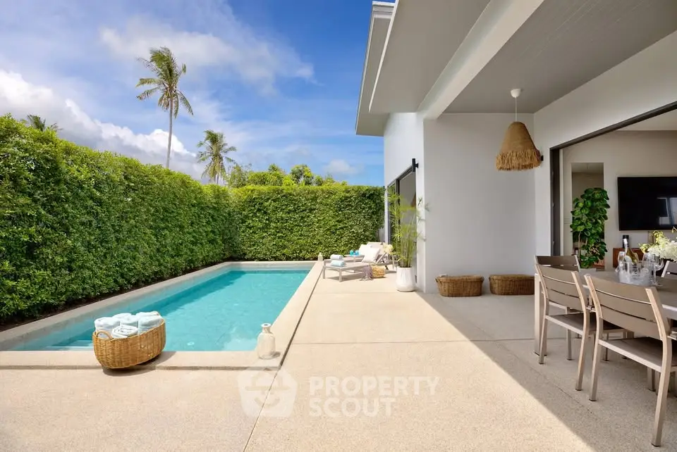 Luxurious modern villa with private pool and outdoor dining area, surrounded by lush greenery.