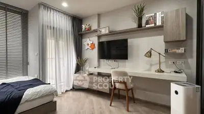 Modern bedroom with stylish decor, featuring a sleek desk, wall-mounted TV, and cozy bed.