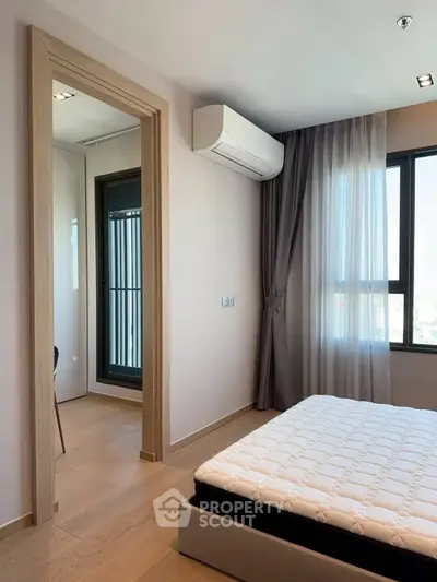Modern bedroom with large window and air conditioning unit