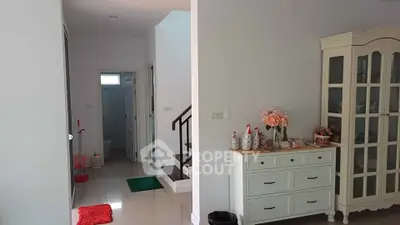 Charming interior with elegant staircase and stylish storage cabinet in a cozy home setting.