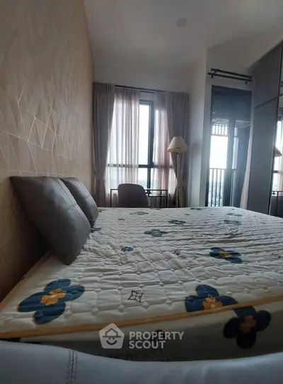 Cozy bedroom with stylish decor and large window offering natural light