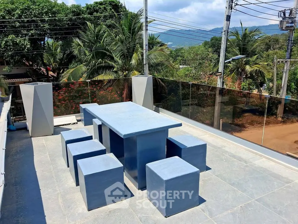 Stunning rooftop terrace with modern seating and scenic views of lush greenery and mountains.