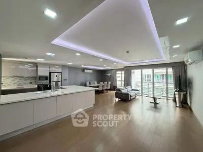Spacious modern living room with open kitchen and balcony access