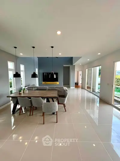 Spacious modern living room with elegant dining area and large windows for natural light.