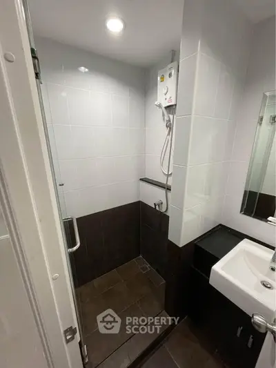 Modern bathroom with sleek shower and stylish sink in contemporary apartment.