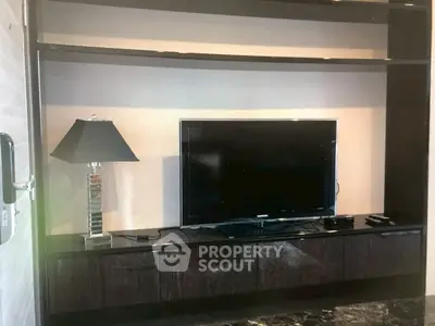 Modern living room with sleek TV stand and stylish lamp, perfect for contemporary living.