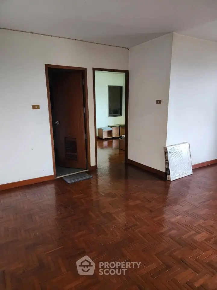 Spacious room with wooden flooring and open doorway in modern apartment