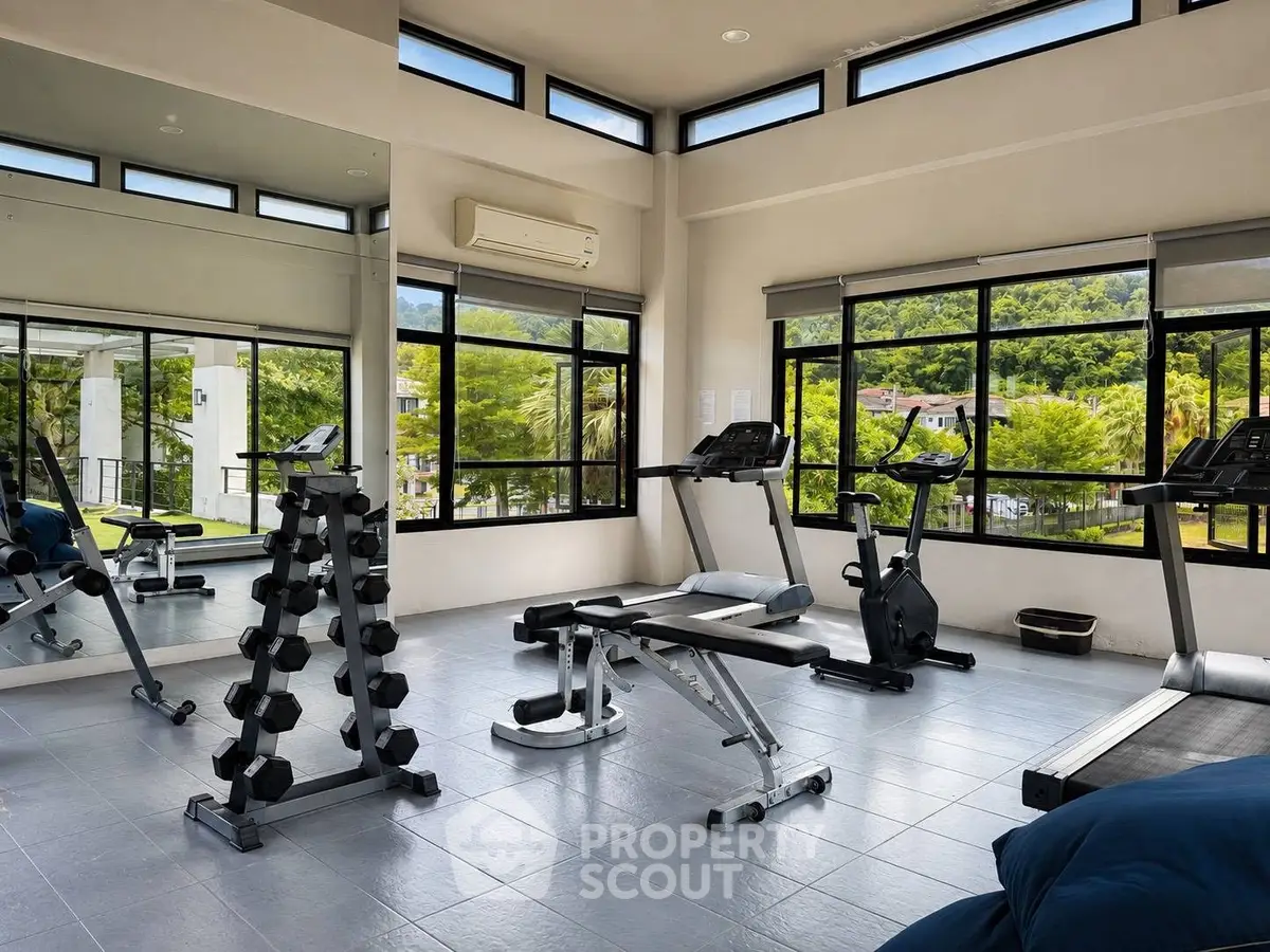 Modern gym with scenic views and state-of-the-art equipment in luxury real estate property.