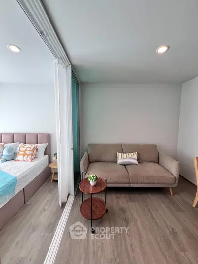 Modern living room with cozy sofa and stylish decor adjacent to bedroom