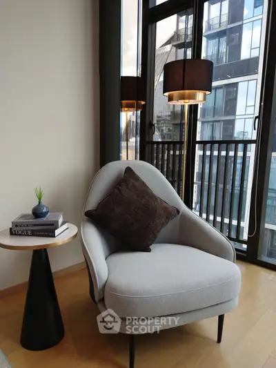 Stylish modern living room with elegant armchair and city view through large windows.