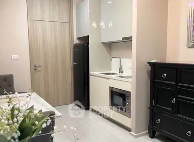 Modern compact kitchen with sleek cabinetry and built-in appliances in a stylish apartment.