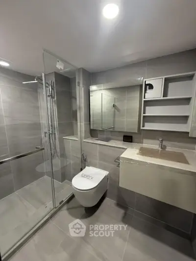 Modern bathroom with glass shower and sleek fixtures in luxury apartment