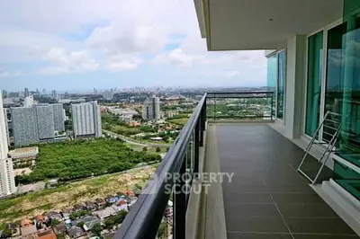 Spacious balcony with stunning cityscape view in modern high-rise apartment.