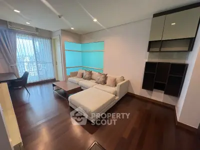 Spacious modern living room with elegant hardwood floors and large windows offering natural light.
