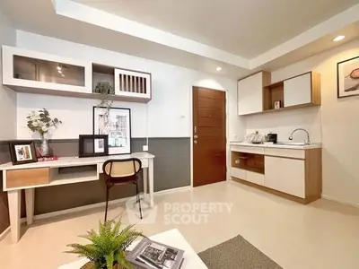 Modern living room with stylish furniture and compact kitchen area, perfect for urban living.