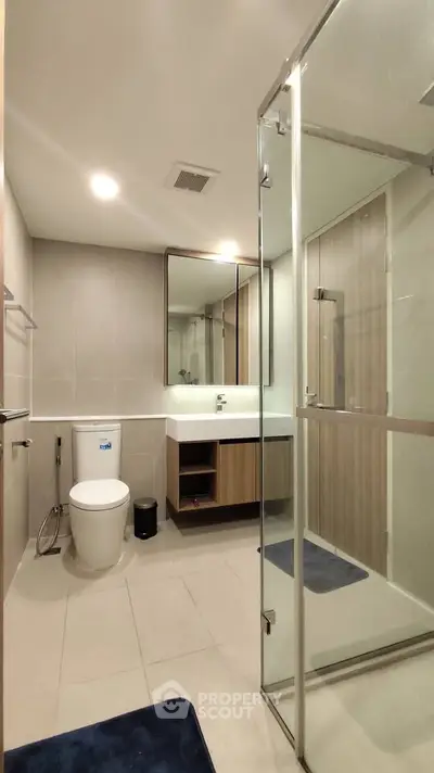 Modern bathroom with glass shower and sleek fixtures in a contemporary apartment.