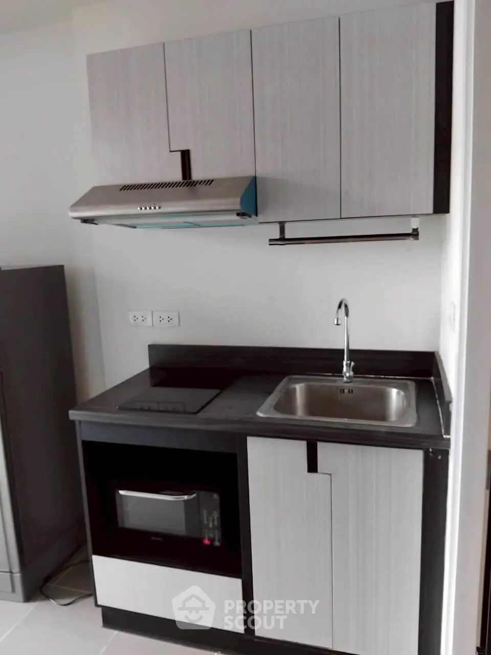 Modern compact kitchen with sleek cabinetry and built-in appliances in a stylish apartment.