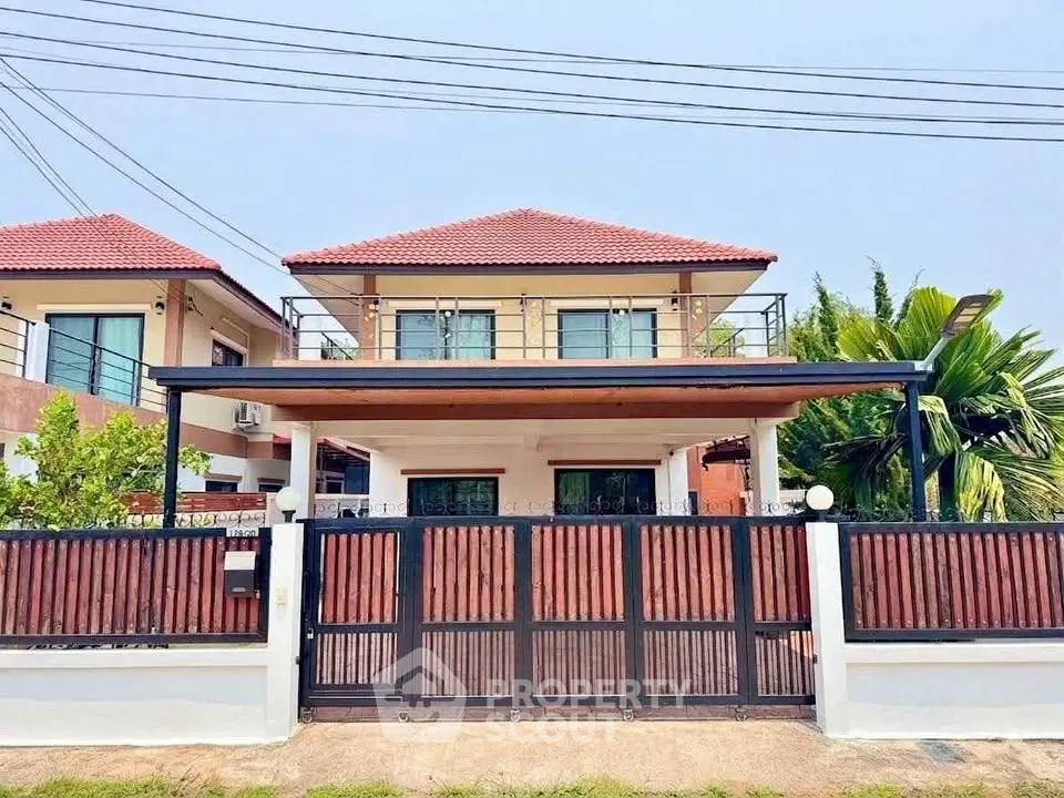 Charming two-story house with red-tiled roof and spacious front yard, perfect for family living.
