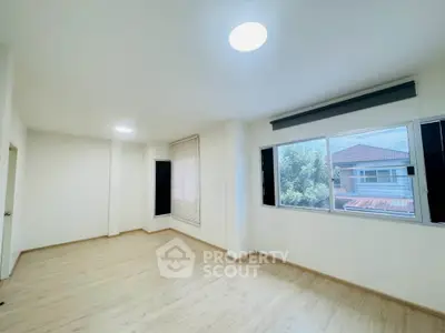 Spacious empty room with large windows and wooden flooring, perfect for customization.