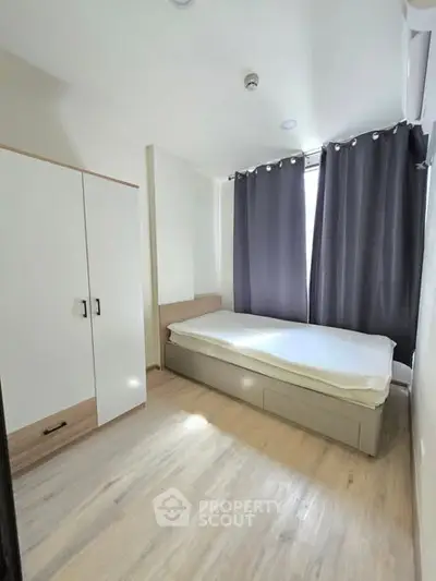 Modern minimalist bedroom with sleek wardrobe and natural light