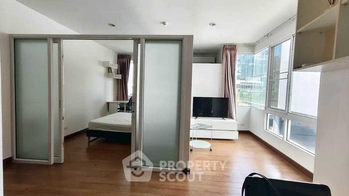 Modern apartment with sliding doors, spacious layout, and large windows offering natural light.