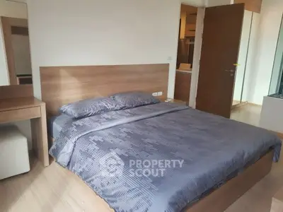 Modern bedroom with wooden furniture and cozy bedding in a stylish apartment.