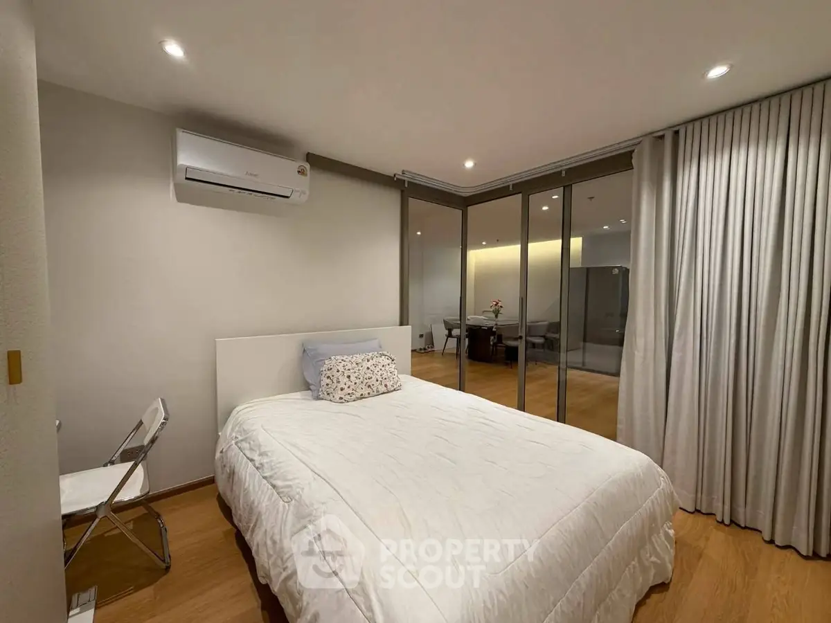 Modern bedroom with air conditioning and glass partition in stylish apartment.