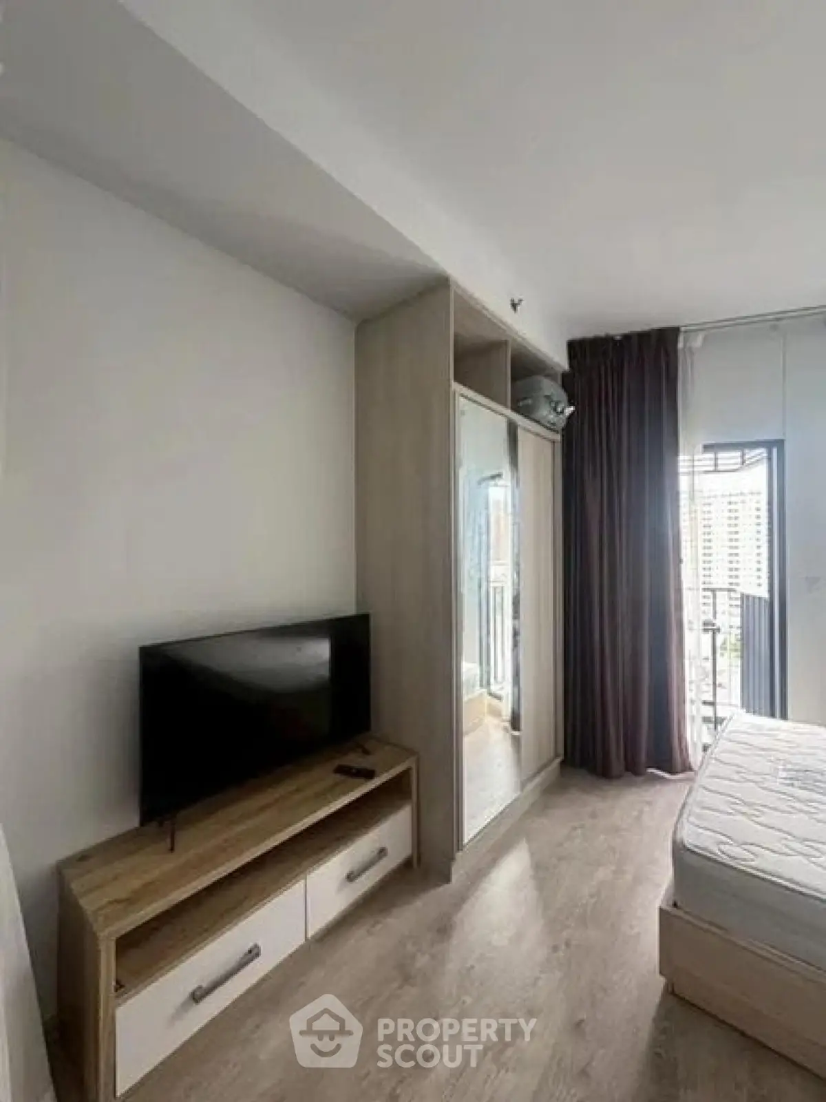 Modern bedroom with balcony view, featuring sleek furniture and natural light.