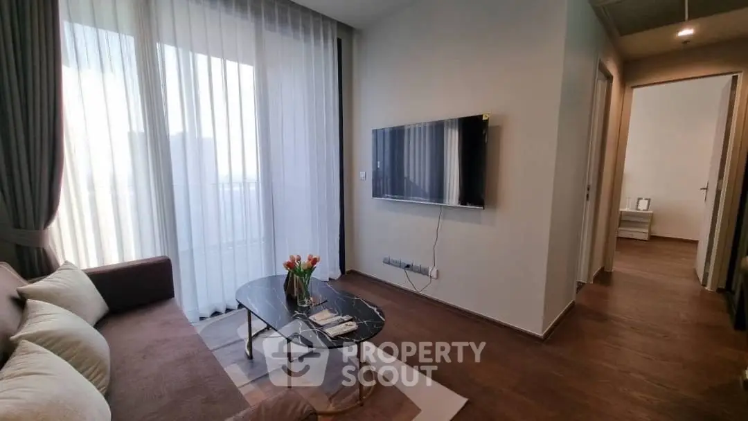 Modern living room with sleek TV and elegant decor in a stylish apartment.