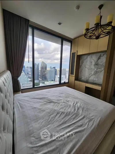 Luxurious bedroom with stunning city view and elegant chandelier in modern high-rise apartment.