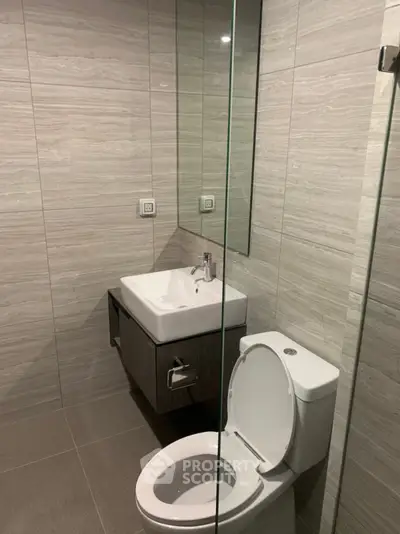 Modern bathroom with sleek design featuring a wall-mounted sink and toilet, ideal for contemporary living.