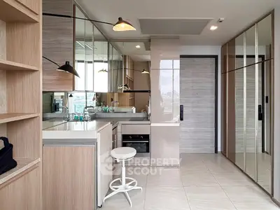 Modern kitchen with sleek cabinetry and mirrored accents in a stylish apartment.