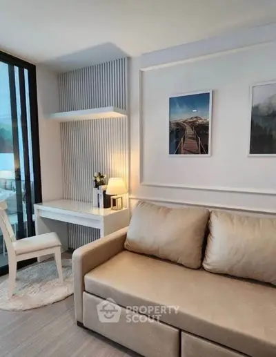 Modern living room with cozy sofa and stylish decor, featuring a small desk and elegant wall art.