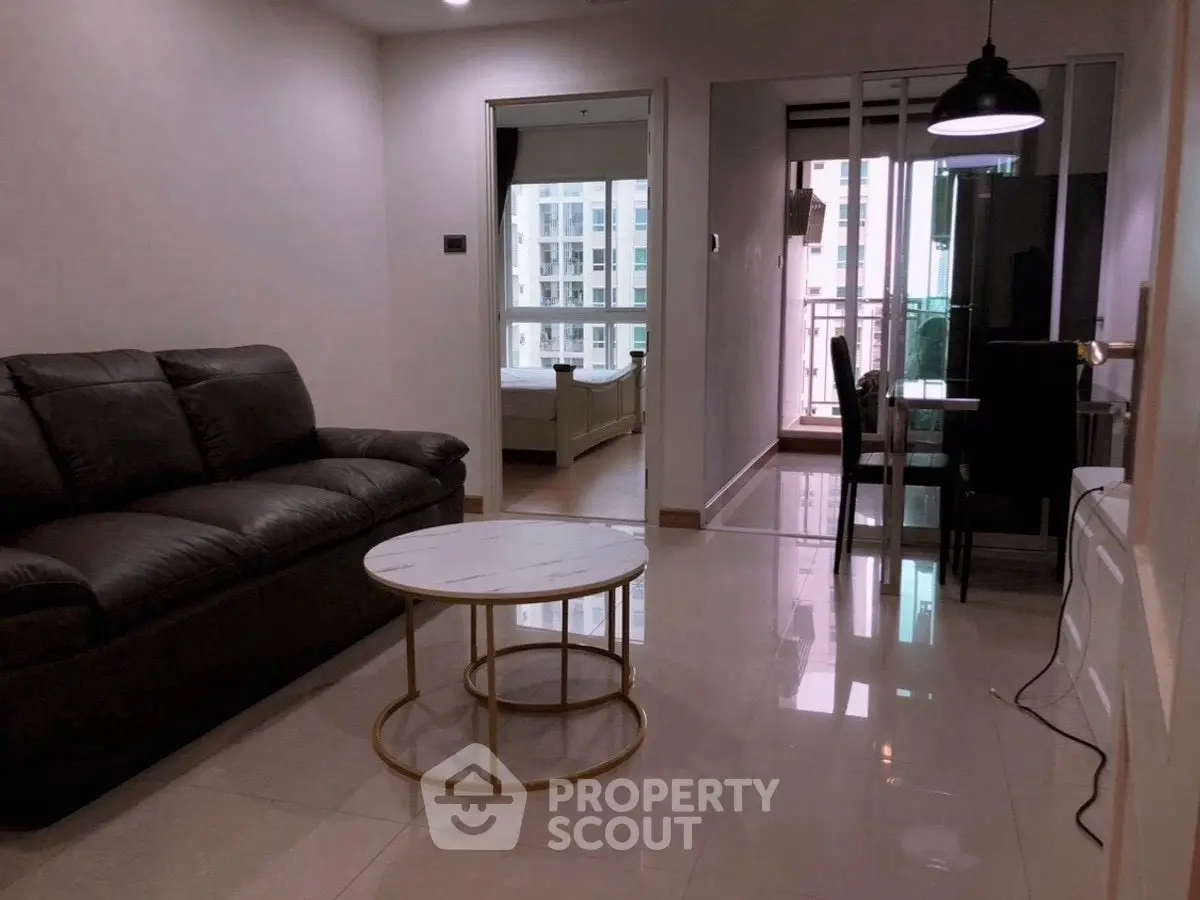 Modern apartment interior with living room, dining area, and balcony view.