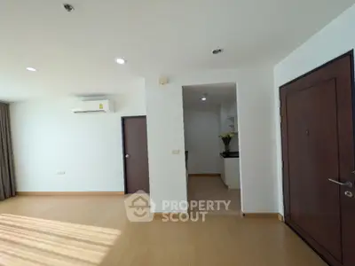 Spacious living room with wooden flooring and modern air conditioning unit