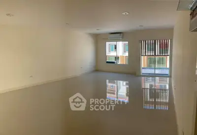 Spacious empty room with large windows and glossy floors, perfect for customization.