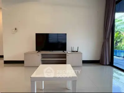 Modern living room with sleek TV setup and poolside view, perfect for relaxation and entertainment.