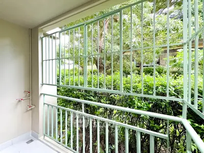 Charming balcony with lush green view and secure railing, perfect for relaxation.