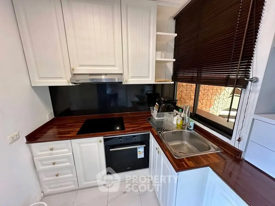 Charming kitchen with sleek black backsplash and wooden countertops