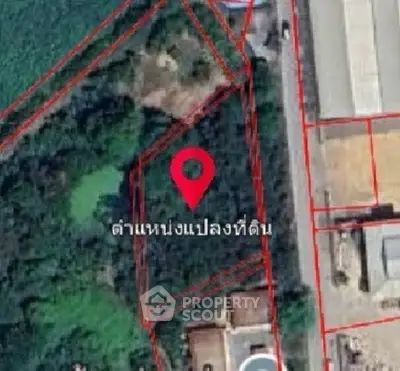 Aerial view of a property plot with red boundary lines and location pin.