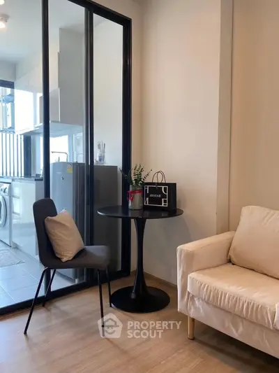 Modern apartment with open kitchen and cozy living area featuring sleek furniture.