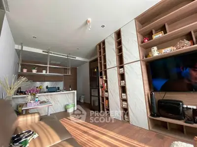 Modern living room with built-in shelves and open kitchen layout, featuring stylish decor and ample natural light.