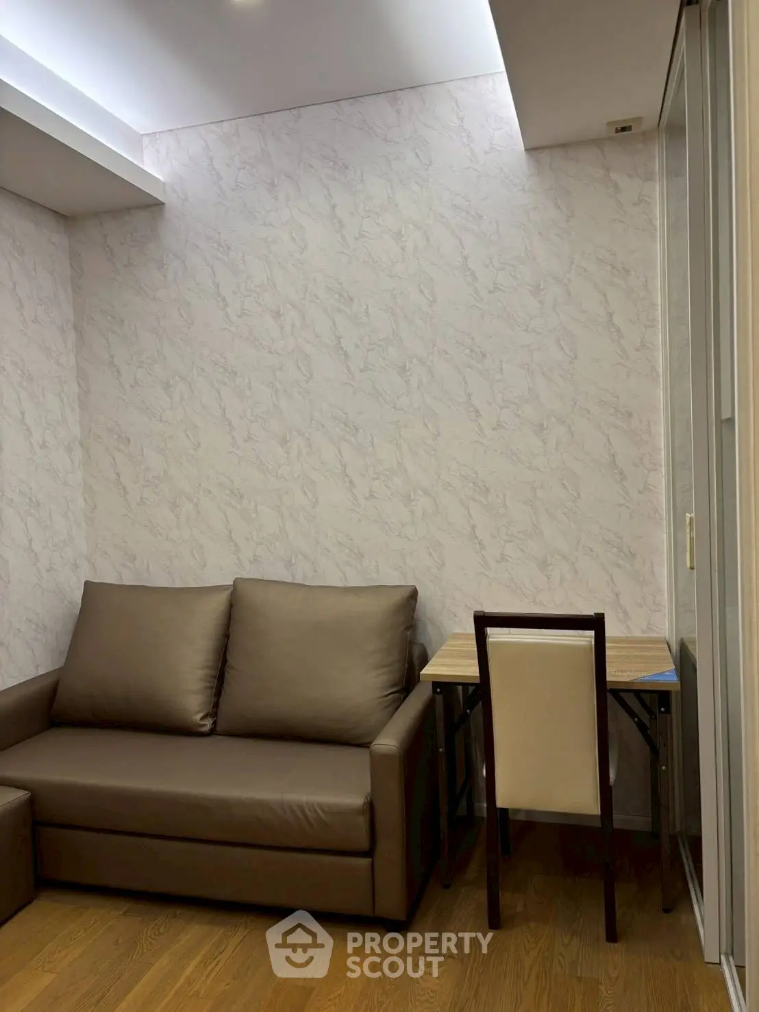 Cozy living room with modern sofa and compact dining area, perfect for urban living.