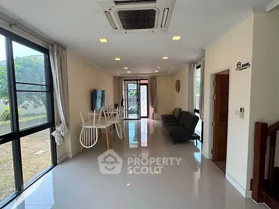 Spacious living room with modern decor and large windows overlooking garden